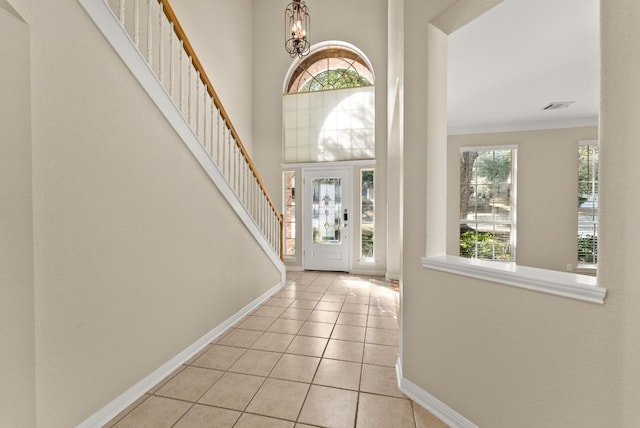 3405 Mulberry Creek Dr, Austin, TX 78732 - tiled foyer entrance with stairway, ornamental molding, and a chandelier