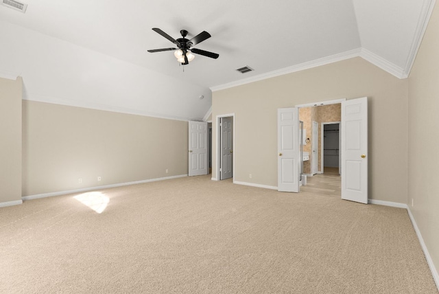 unfurnished bedroom featuring light colored carpet, vaulted ceiling, crown molding, and visible vents