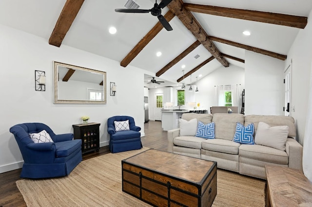 living room with lofted ceiling with beams, baseboards, and wood finished floors