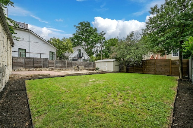 view of yard featuring an outdoor structure, a fenced backyard, a shed, and a patio