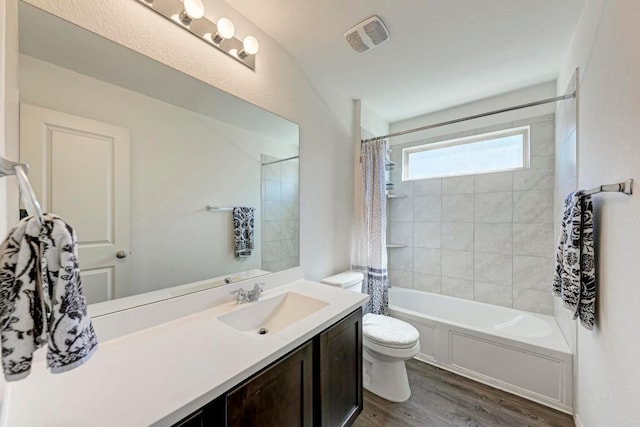 full bathroom with visible vents, toilet, shower / tub combo with curtain, wood finished floors, and vanity