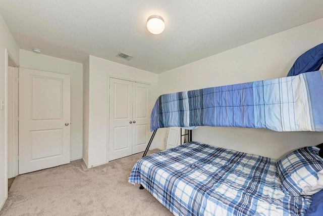 bedroom with a closet, visible vents, and carpet floors