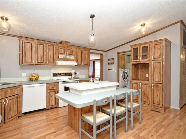 kitchen featuring white appliances, ventilation hood, washing machine and dryer, and crown molding