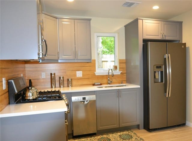 kitchen featuring gray cabinets, appliances with stainless steel finishes, and a sink