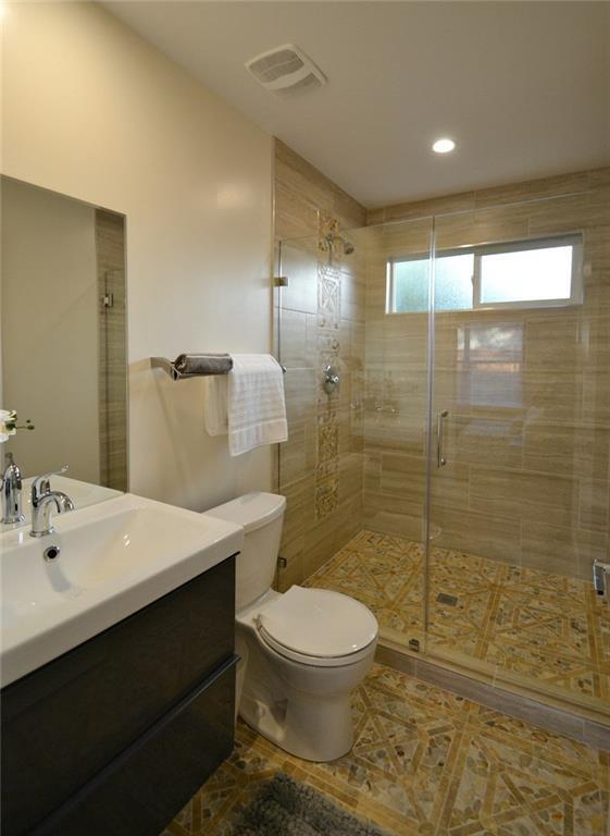 full bathroom featuring vanity, toilet, visible vents, and a stall shower