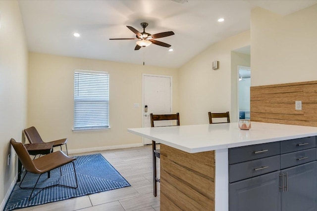 1705 E 14th St Unit B, Austin, TX 78702 - kitchen with ceiling fan, gray cabinets, a kitchen bar, light countertops, and baseboards