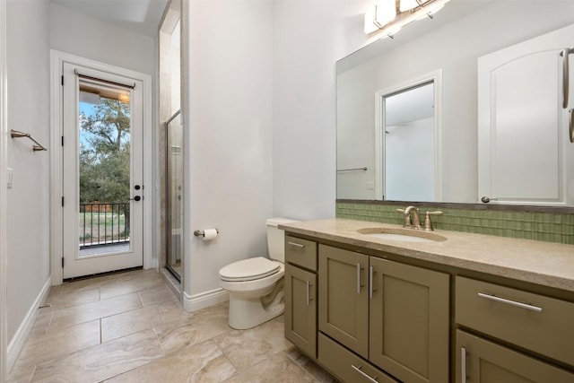 bathroom with a shower stall, backsplash, baseboards, toilet, and vanity