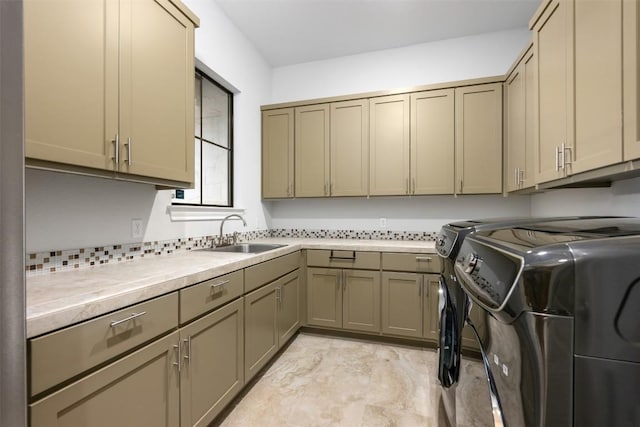 washroom featuring a sink, cabinet space, and washer and clothes dryer