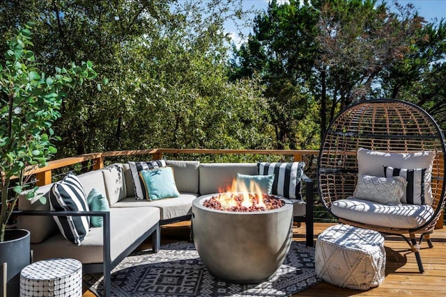 wooden terrace featuring an outdoor living space with a fire pit