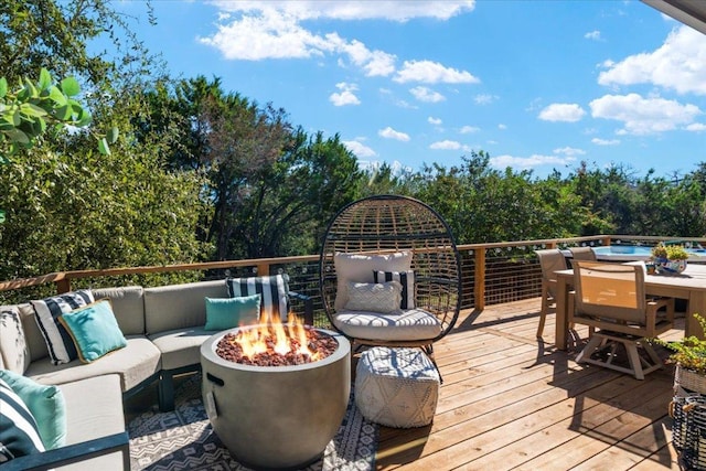 wooden deck with an outdoor living space with a fire pit and outdoor dining space