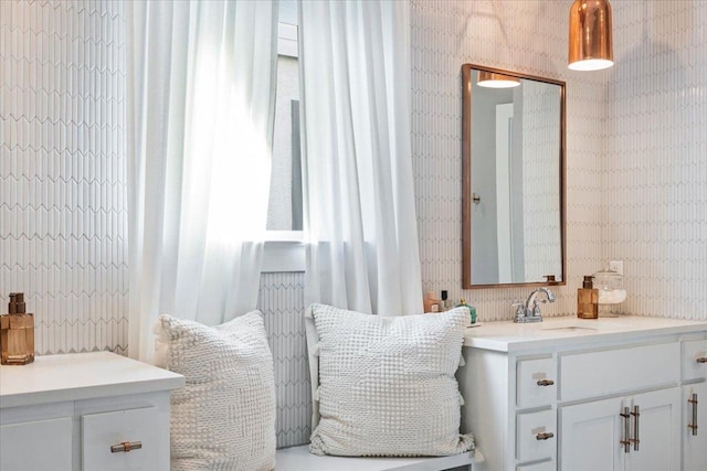 bathroom featuring vanity and wallpapered walls