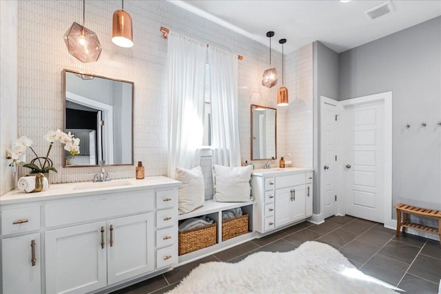 full bath with a sink, visible vents, two vanities, and tile patterned flooring