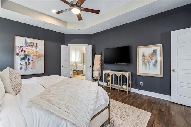 bedroom featuring visible vents, ceiling fan, baseboards, wood finished floors, and a raised ceiling