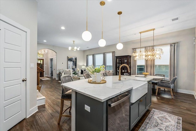 kitchen with dark wood-type flooring, a sink, stainless steel dishwasher, arched walkways, and an inviting chandelier