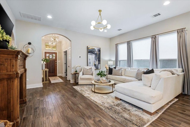 living room featuring dark wood finished floors, a notable chandelier, and visible vents