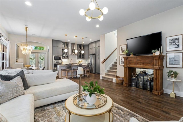 living area featuring a notable chandelier, dark wood-style floors, recessed lighting, french doors, and a fireplace