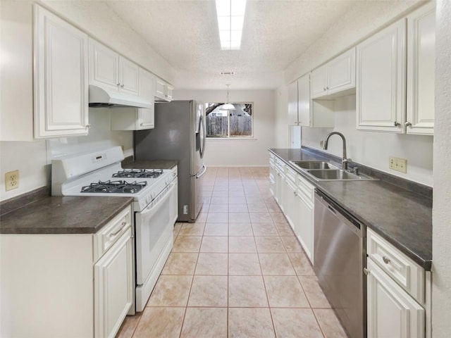 11510 Powder Mill Trl, Austin, TX 78750 - kitchen with stainless steel appliances, under cabinet range hood, a sink, dark countertops, and a textured ceiling