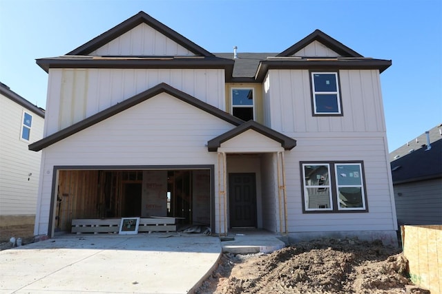 view of front of property with board and batten siding, concrete driveway, and an attached garage