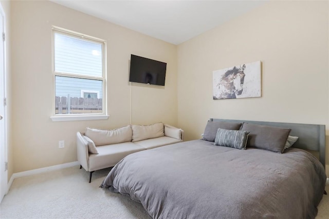 bedroom with baseboards and light carpet