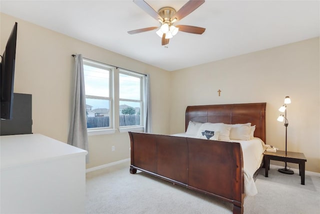 bedroom with baseboards, light colored carpet, and a ceiling fan