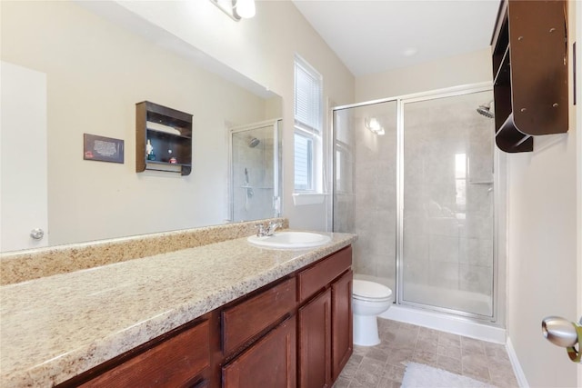 bathroom featuring a stall shower, toilet, vanity, and baseboards