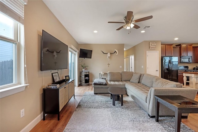 living area featuring a ceiling fan, baseboards, visible vents, light wood-style flooring, and recessed lighting