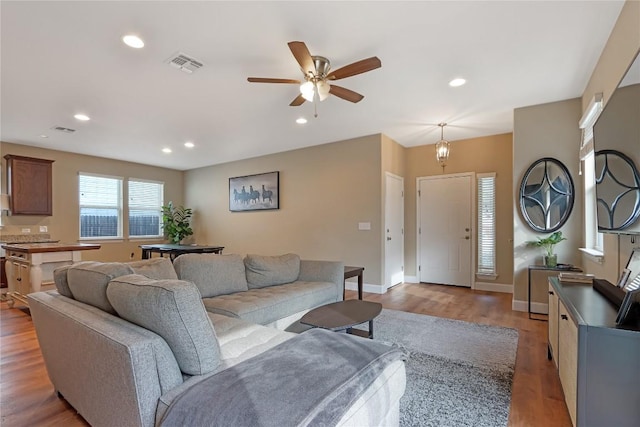 living area featuring recessed lighting, light wood-type flooring, baseboards, and visible vents