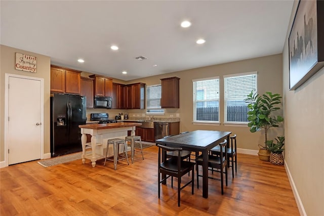 dining space with light wood-type flooring, visible vents, baseboards, and recessed lighting