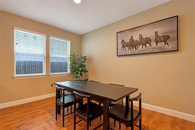 dining space featuring baseboards and light wood-style floors