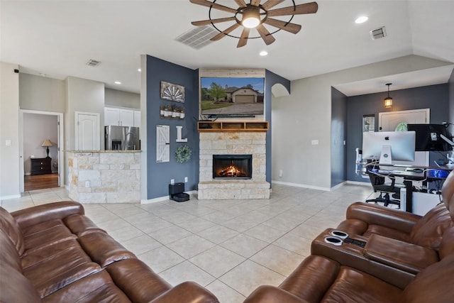 living area with light tile patterned floors, a ceiling fan, visible vents, and baseboards