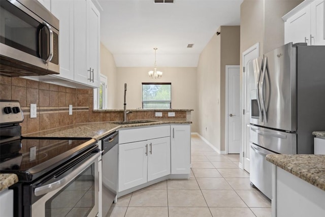 kitchen featuring a sink, tasteful backsplash, white cabinetry, appliances with stainless steel finishes, and light tile patterned floors