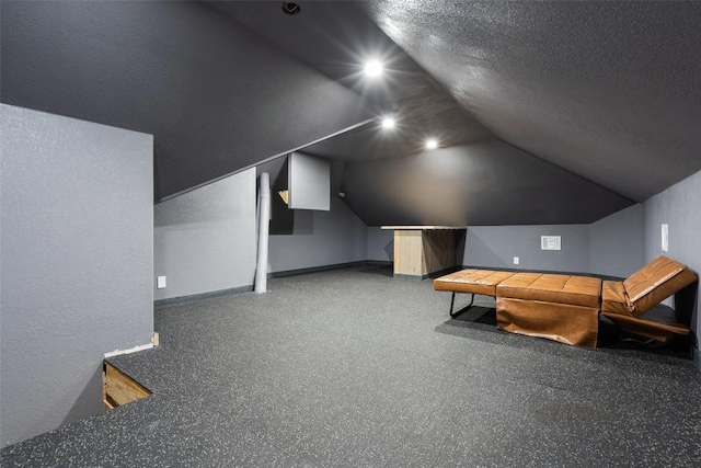 bonus room featuring lofted ceiling, baseboards, and a textured ceiling