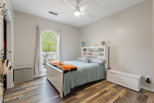 bedroom featuring visible vents, a ceiling fan, and wood finished floors