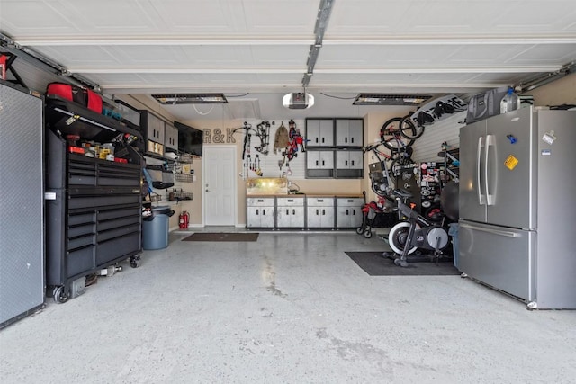 garage with a garage door opener and freestanding refrigerator