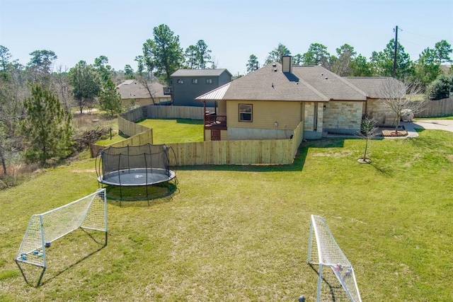 view of yard featuring a trampoline and fence