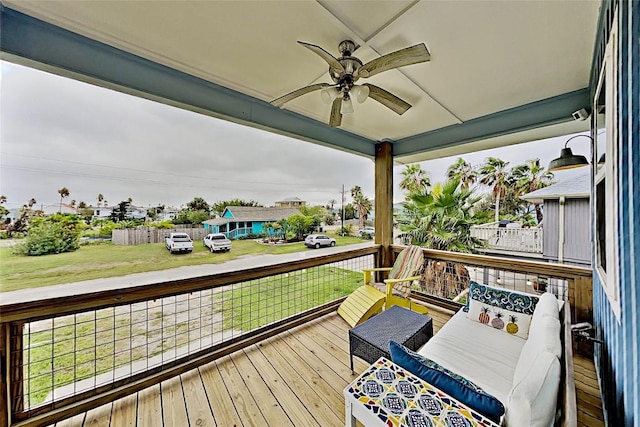 wooden deck featuring outdoor lounge area, a lawn, and a ceiling fan