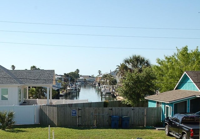 view of yard featuring a water view and fence