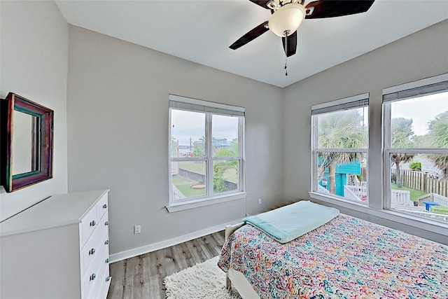 bedroom featuring baseboards, a ceiling fan, and light wood finished floors