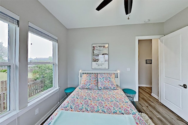 bedroom featuring a ceiling fan, wood finished floors, and baseboards