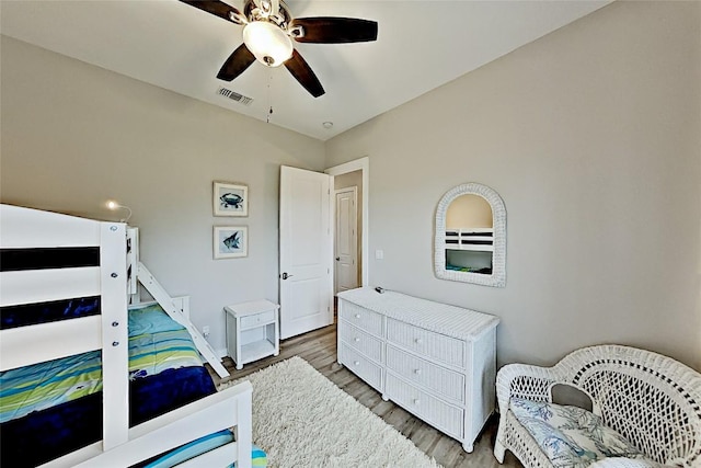 bedroom with visible vents, baseboards, a ceiling fan, and wood finished floors