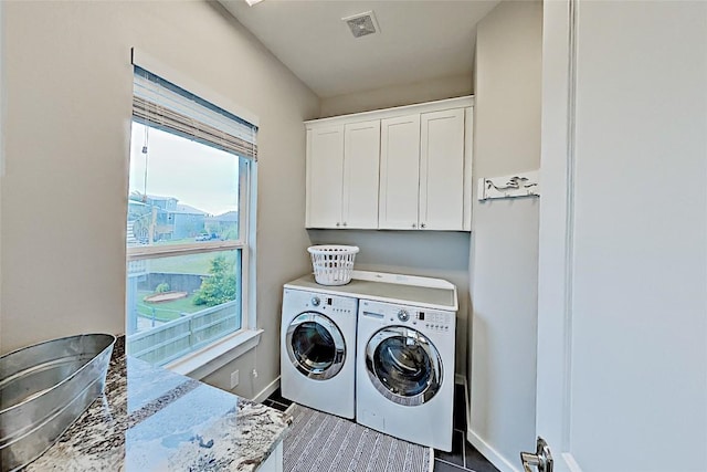 laundry room featuring visible vents, cabinet space, baseboards, and washing machine and clothes dryer