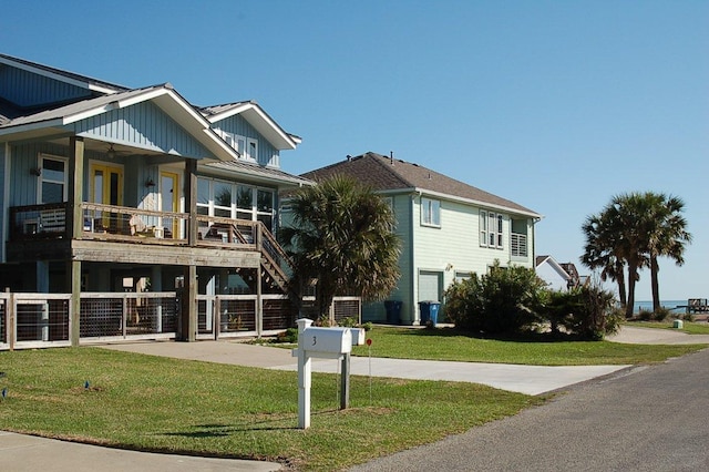 view of front of house featuring metal roof, stairway, a front yard, and a standing seam roof