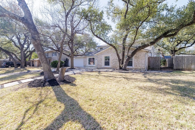 single story home with stone siding, a front yard, a garage, and fence