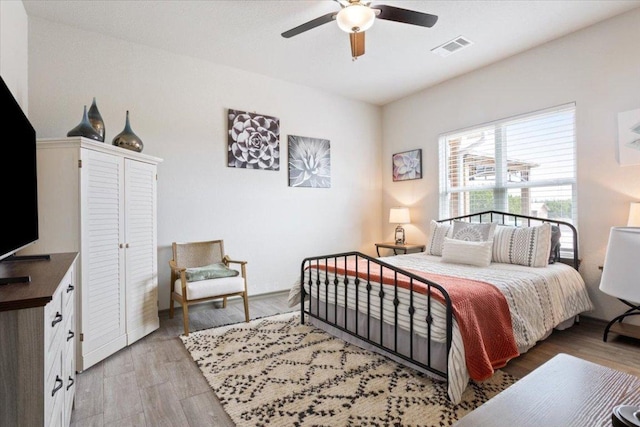 bedroom with visible vents, ceiling fan, and light wood finished floors