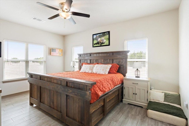 bedroom featuring visible vents, light wood-style flooring, and a ceiling fan