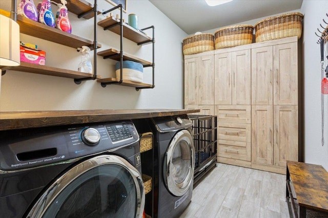 laundry room featuring separate washer and dryer, light wood-style flooring, and laundry area