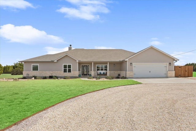 ranch-style house with fence, concrete driveway, a front yard, a garage, and stone siding