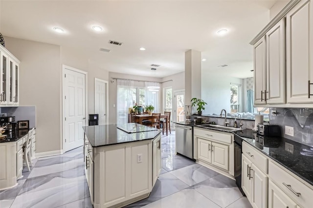 4514 Harvey Penick Dr, Round Rock, TX 78664 - kitchen featuring stainless steel dishwasher, a kitchen island, plenty of natural light, recessed lighting, and glass insert cabinets