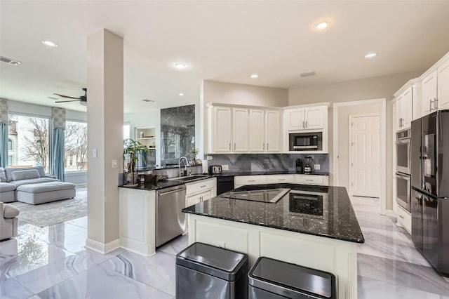 4514 Harvey Penick Dr, Round Rock, TX 78664 - kitchen featuring appliances with stainless steel finishes, open floor plan, light marble finish flooring, decorative backsplash, and recessed lighting