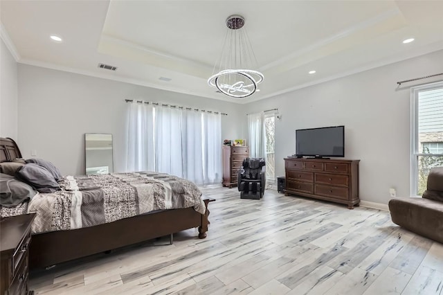 bedroom featuring light wood finished floors, visible vents, a chandelier, and a raised ceiling